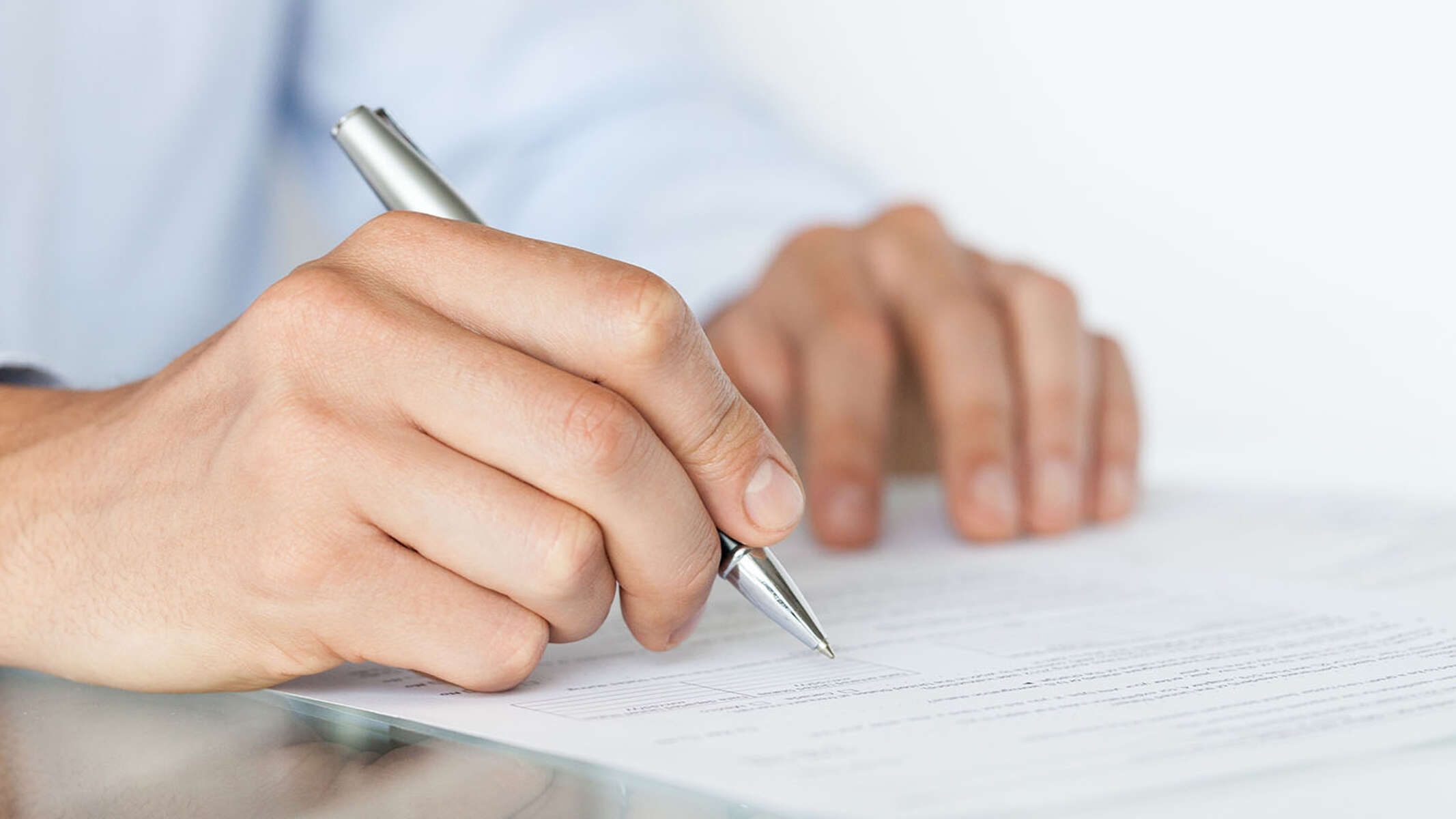 Hand, die einen Vertrag unterschreibt.