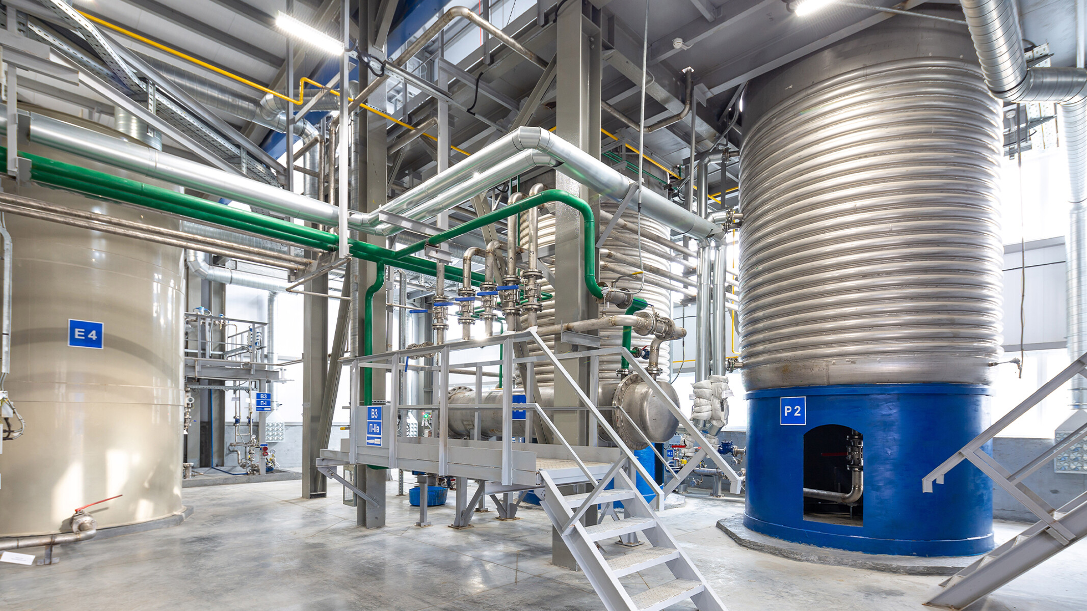 Impianti di grandi dimensioni e tubazioni a soffitto in uno stabilimento per prodotti chimici di consumo
