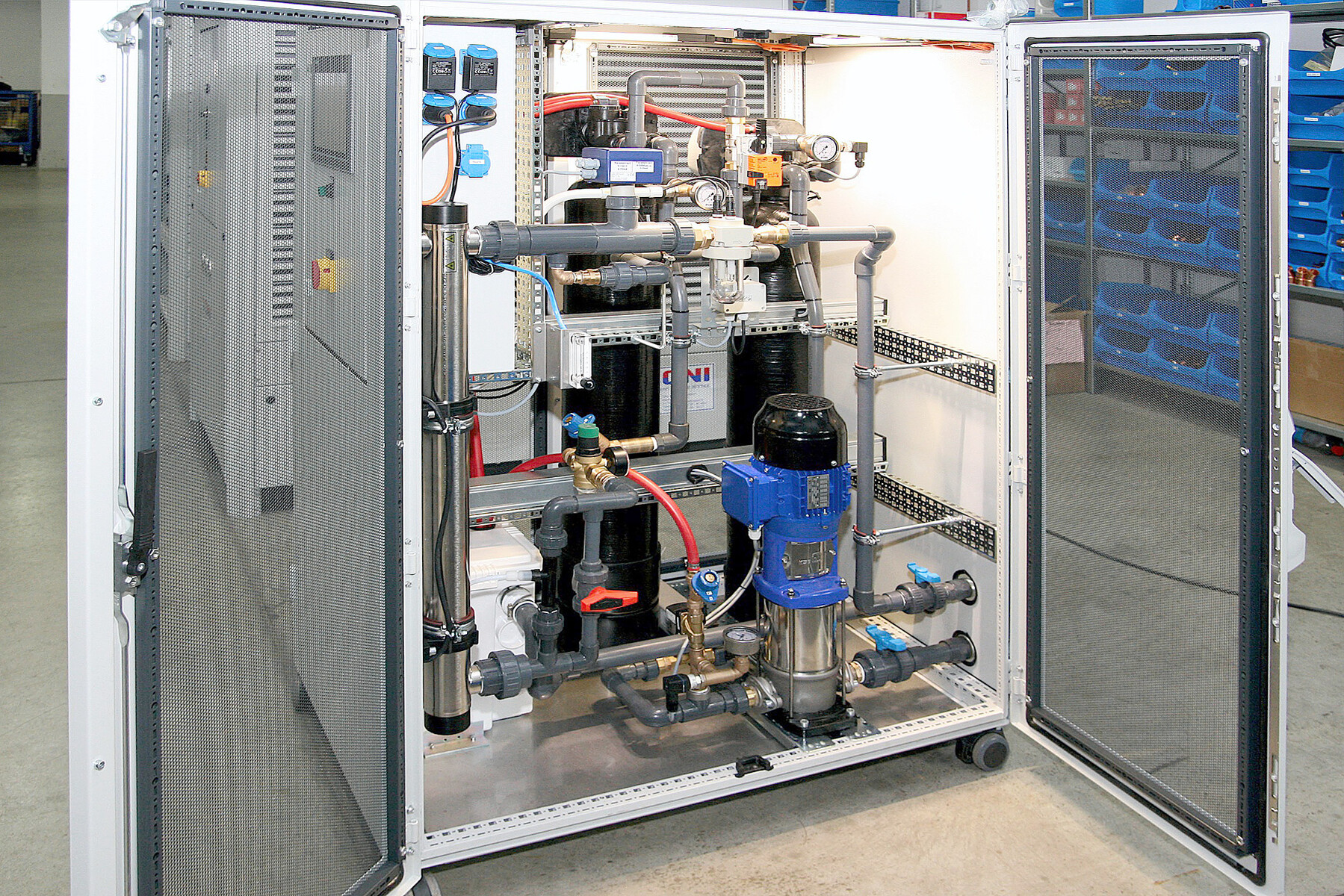 Geöffnete Seitenwand einer ONI-AquaClean-Filterspülstation mit Rohrleitungen und KSB-Pumpe