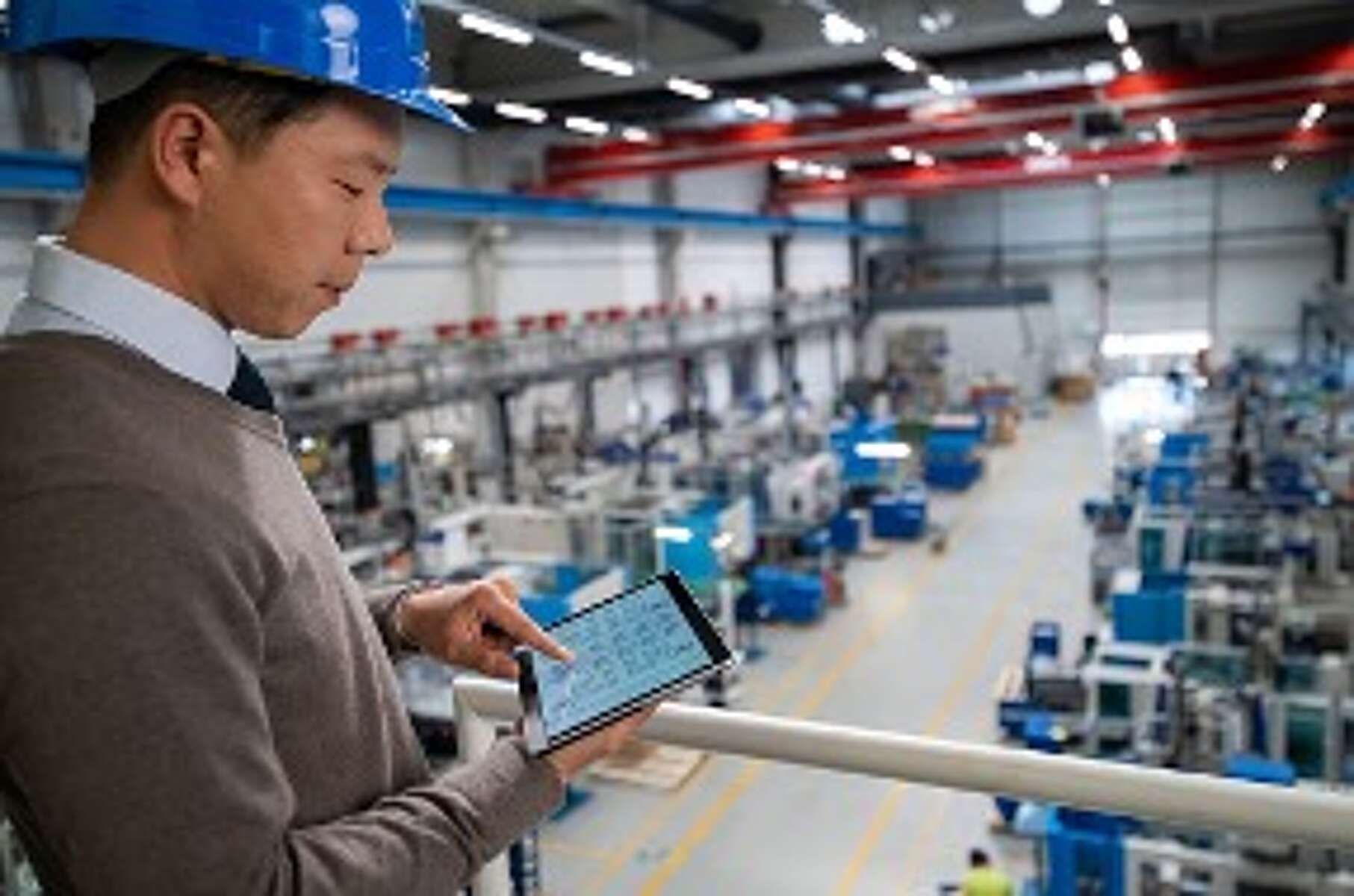 Service-Mitarbeiter beim Check digitaler Pumpensteuerung an einer Anlage.