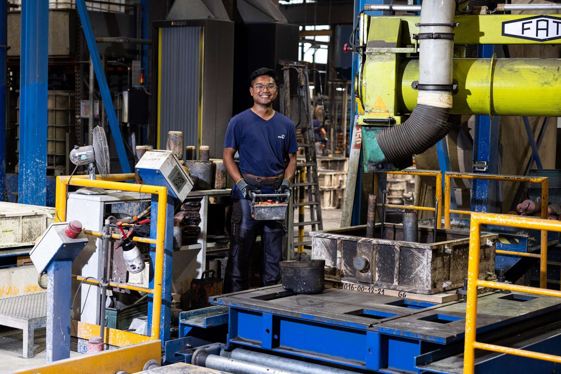 Ein Gießereichmechaniker kontrolliert Daten auf einem Tablet.