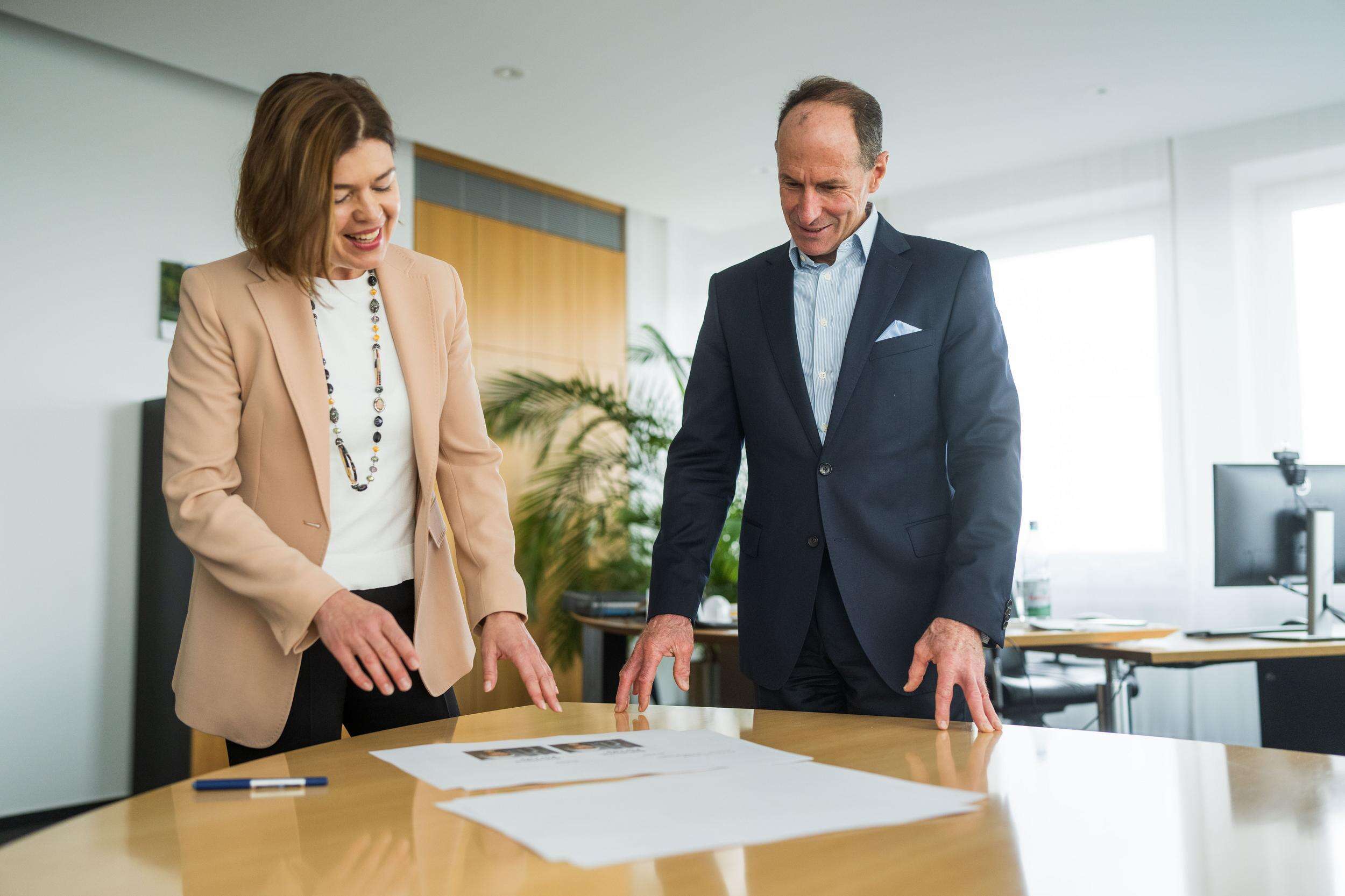 Sonja Ayasse and Dr Stephan Timmermann look at a draft of the new logo while standing together at a table.