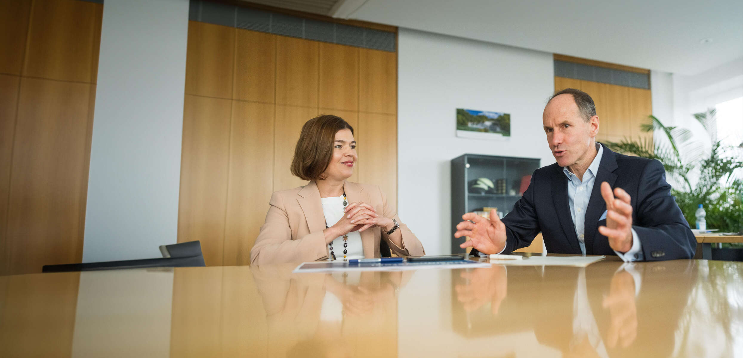 Dr Stephan Timmermann och Sonja Ayasse samtalar medan de sitter vid ett bord