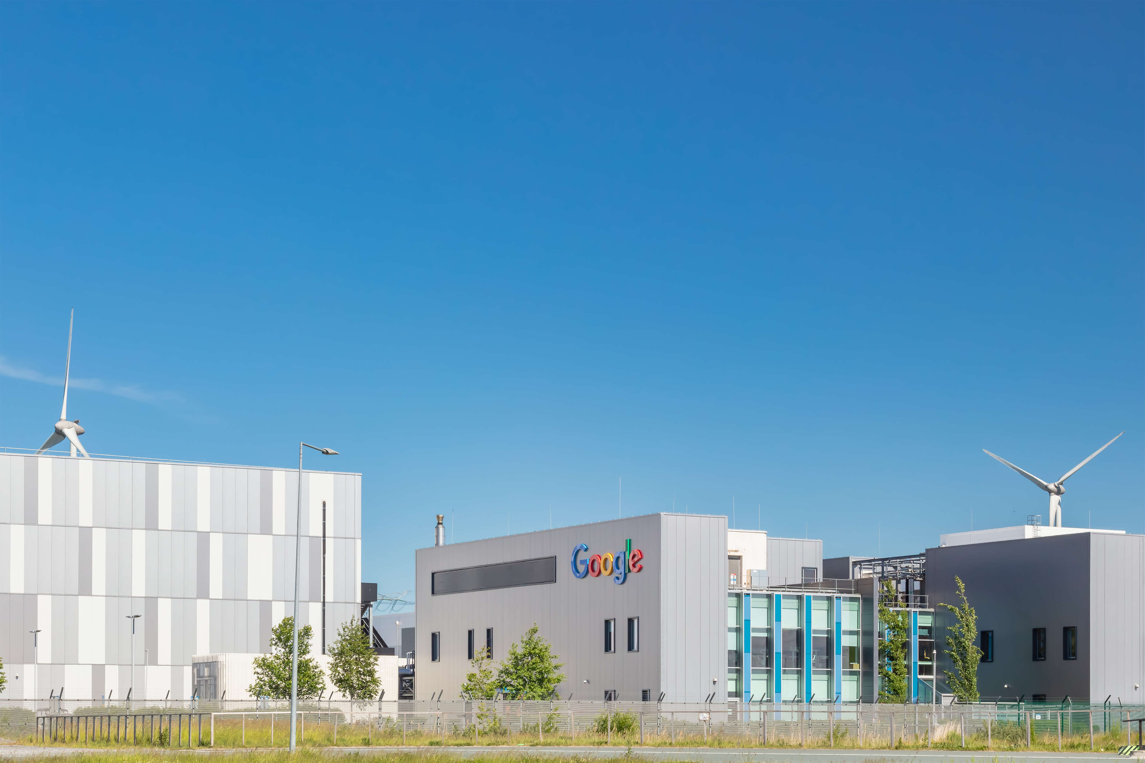 A Google data centre with two wind turbines in the background