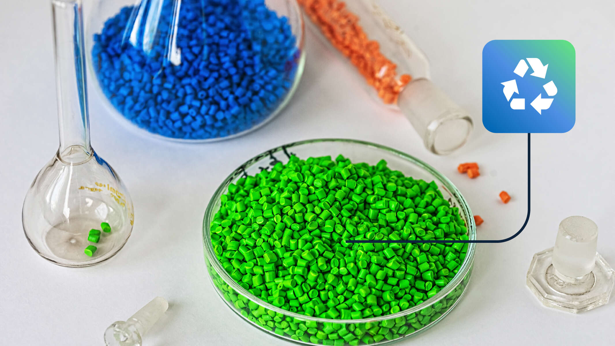 Grüne, blaue und orange Kunststoffgranulate in Gläsern mit Recycling-Symbol – Symbol für nachhaltiges Kunststoffrecycling.