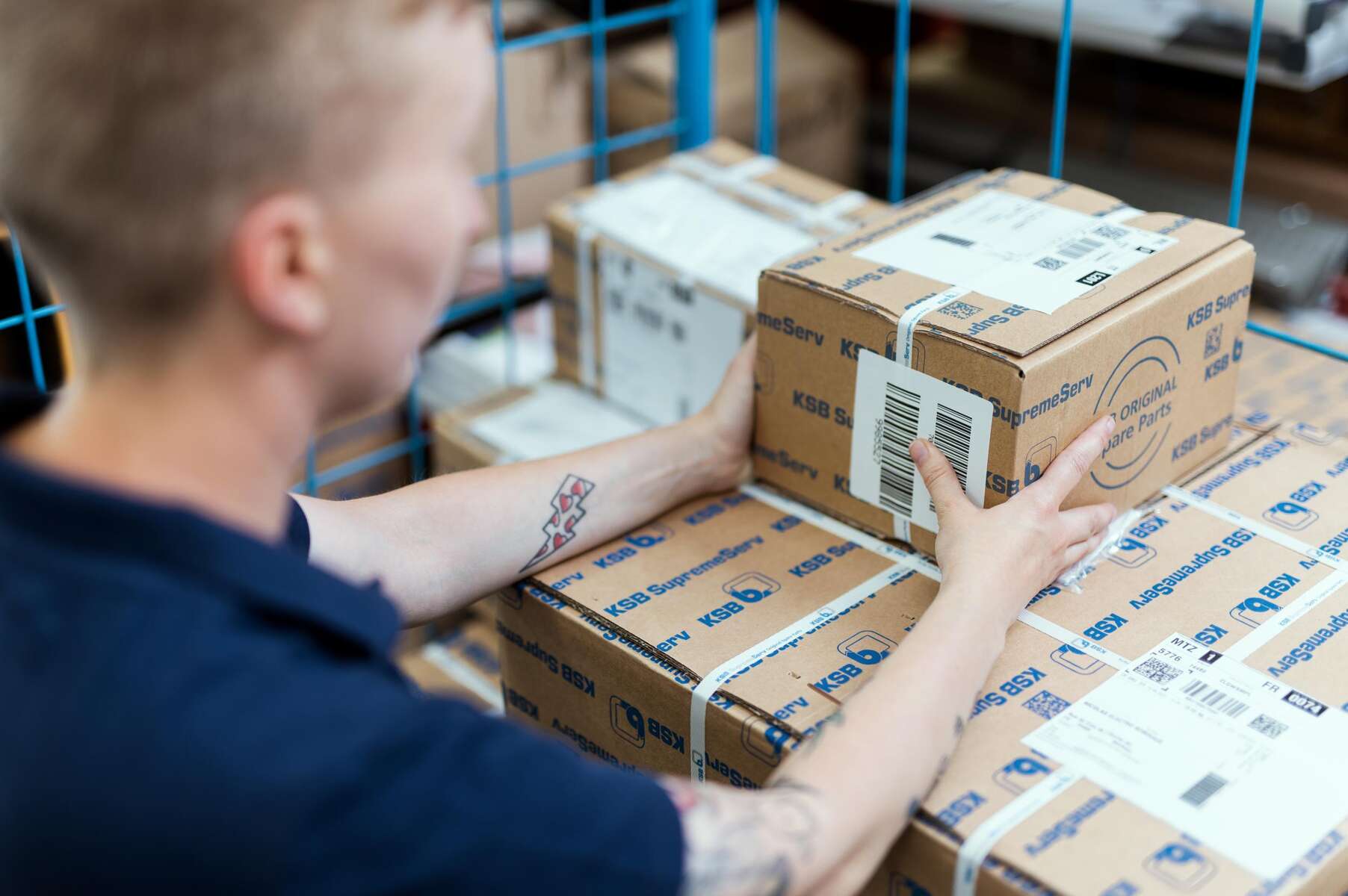 Eine KSB-Mitarbeiterin macht ein Paket für den Versand fertig.