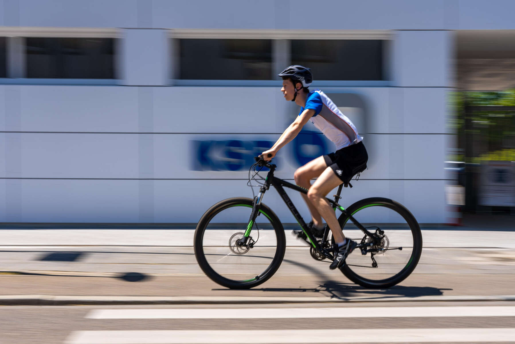 A KSB employee on a bicycle in front of the KSB company headquarters