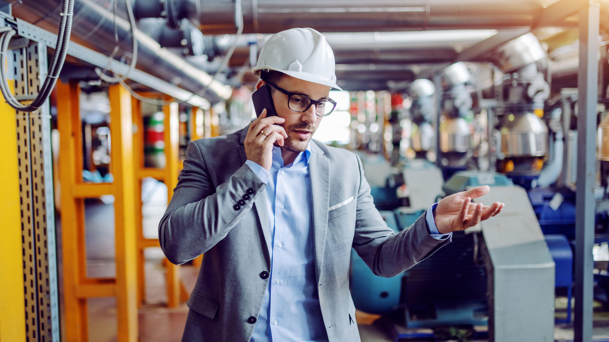 An engineer using a smartphone in a power plant