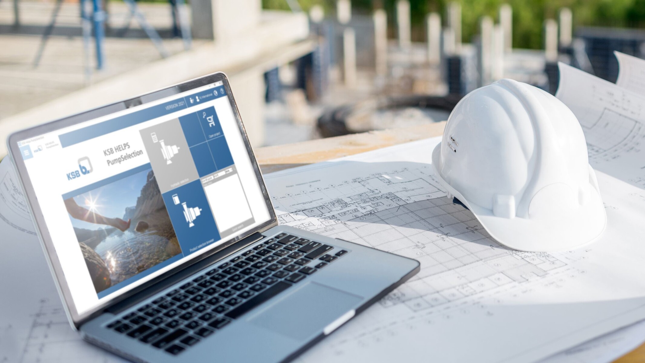 Planer über Pläne gebeugt, im Hintergrund ein Laptop mit der Software KSB Helps PumpSelection auf dem Screen