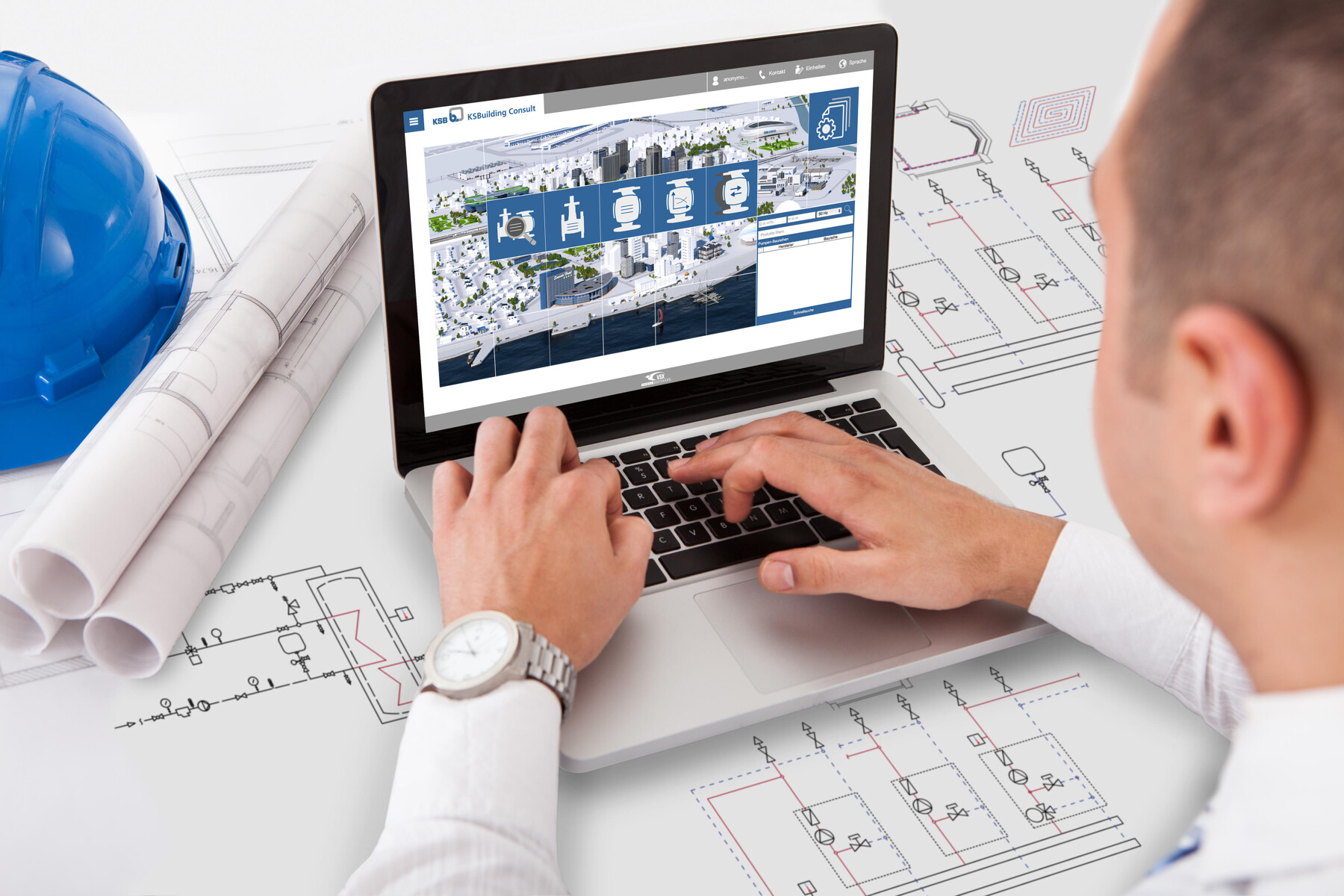 Planer in der Gebäudetechnik über Pläne gebeugt, im Hintergrund Laptop mit KSBuilding Consult auf dem Screen.