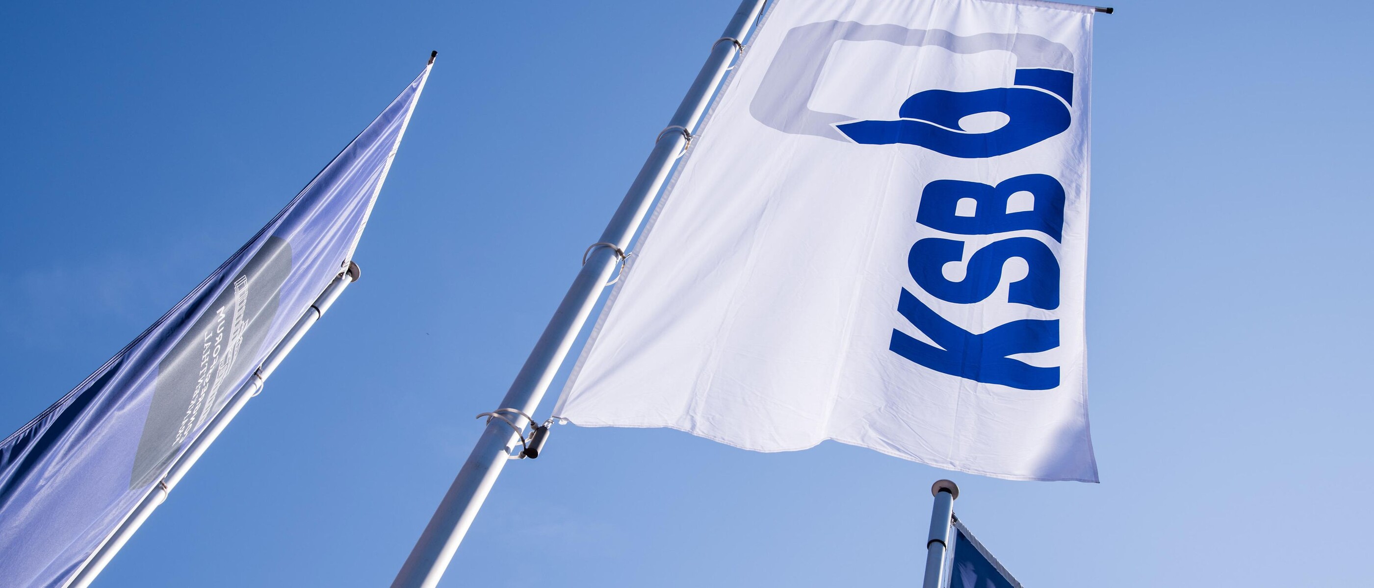 Bandeiras da KSB contra um céu azul