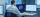 Man sitting in a data centre in front of computer monitors