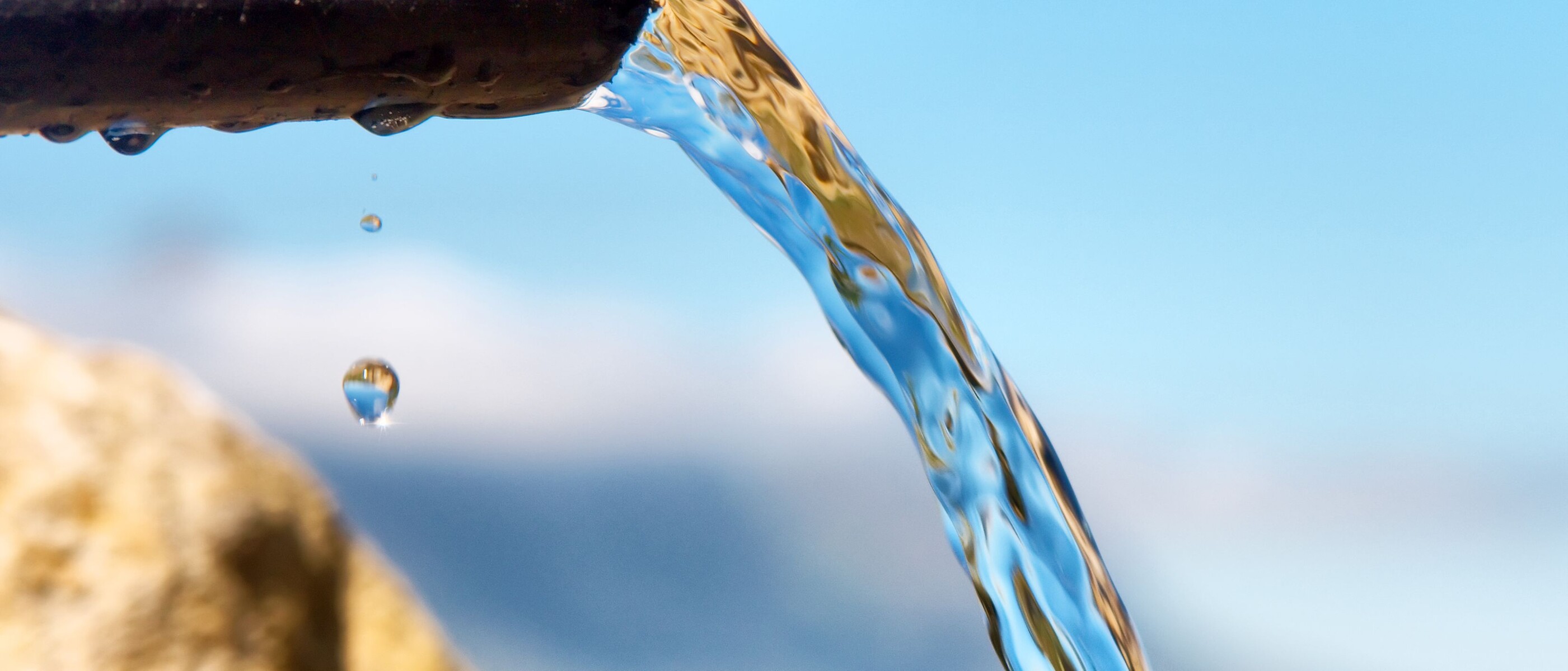 Clear water flows through a pipe into a water body