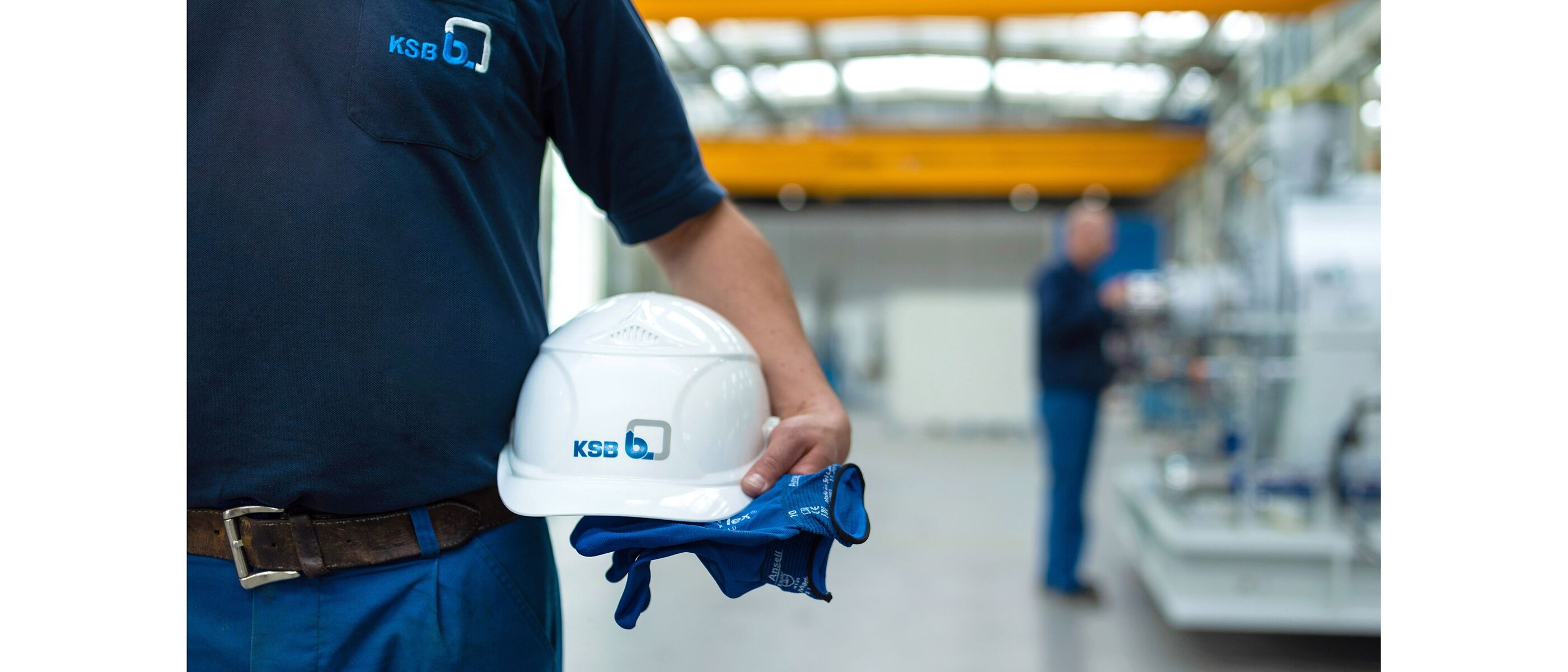 KSB employee holding a hard hat and gloves