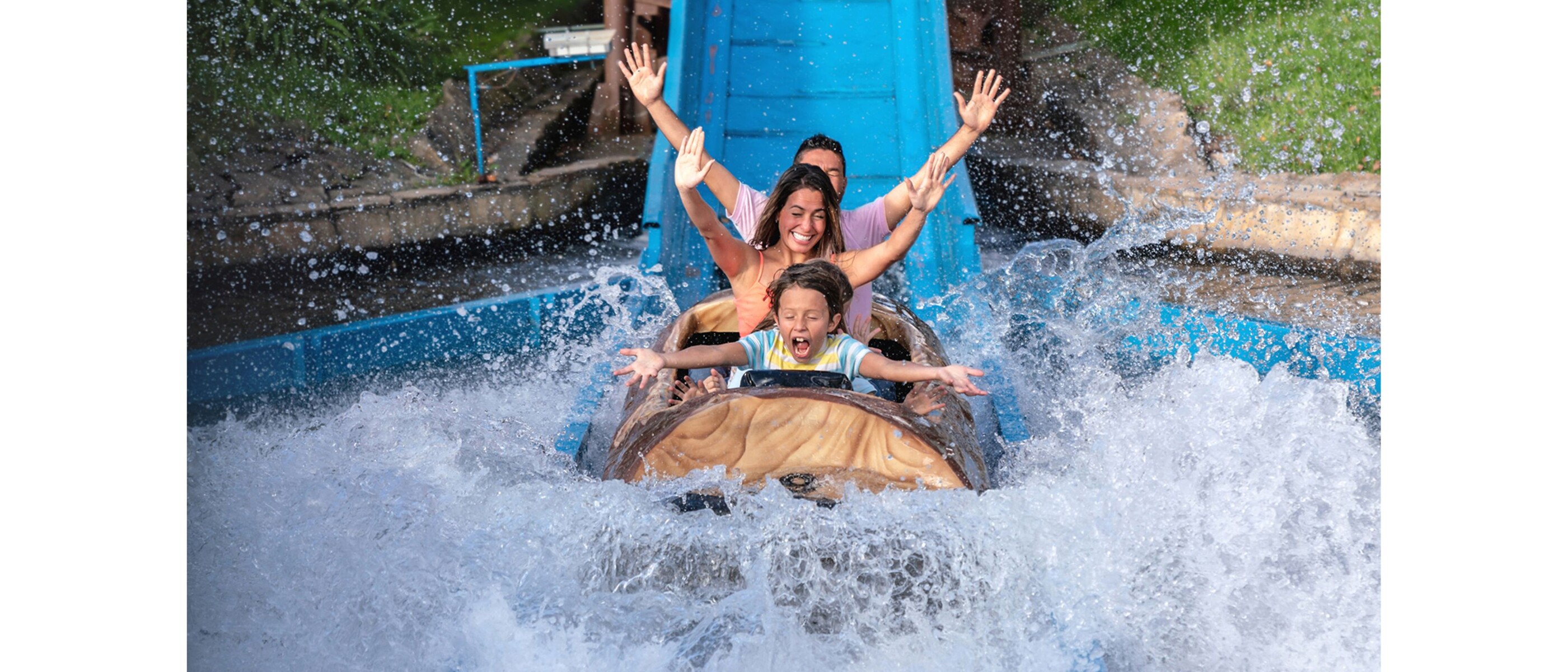A family on a white water ride. The water splashes.