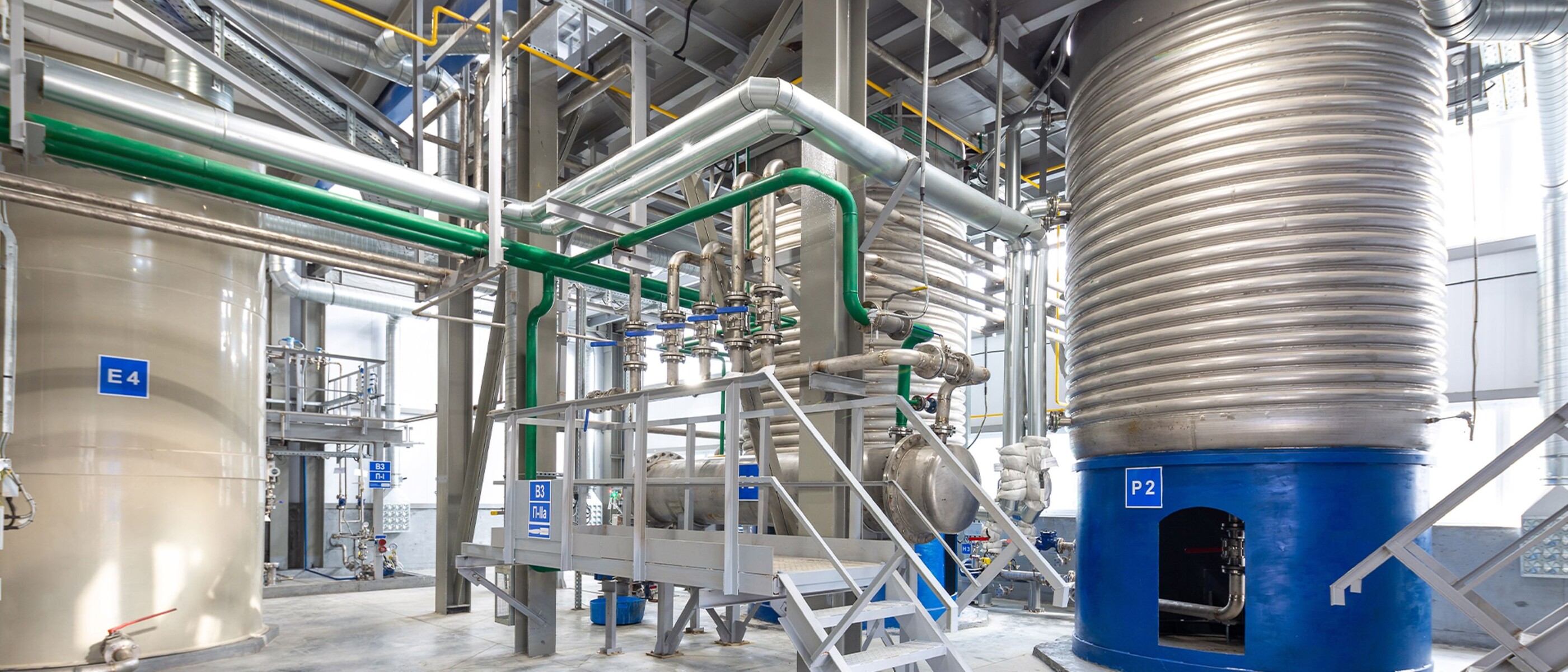 Sistemas de grande escala e tubagens de tecto numa fábrica de produtos químicos de consumo